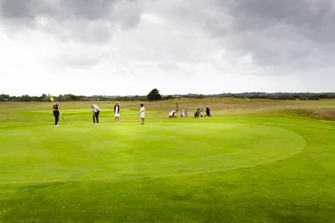 Three couples golf player playing golf in professional golf course. Stock Photos