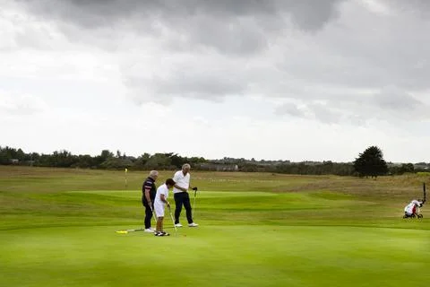 Three couples golf player playing golf in professional golf course. Stock Photos