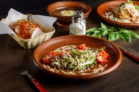 Three-course dinner, tea and a bun. In the foreground salad with chicken breast. Stock Photos