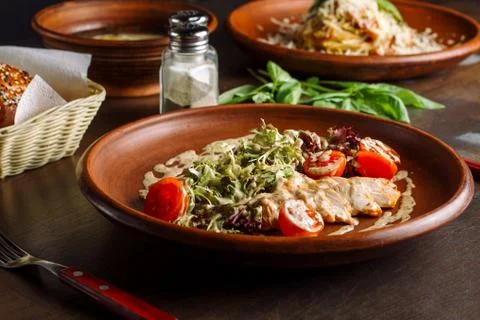 Three-course dinner, tea and a bun. In the foreground salad with chicken breast. 스톡 사진