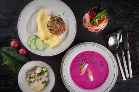 Three-course set on a table in a business lunch restaurant. Pink creme soup. 스톡 사진