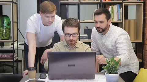 Three coworkers discuss information using computer in office. Stock Footage 78566199
