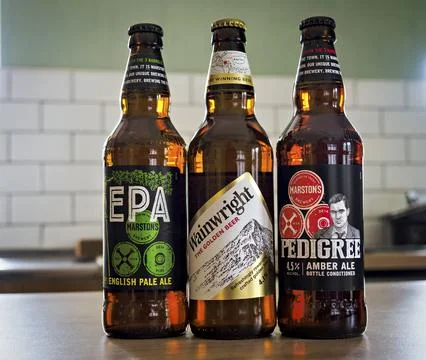 Three craft beer bottles on a kitchen counter. Stock Photos