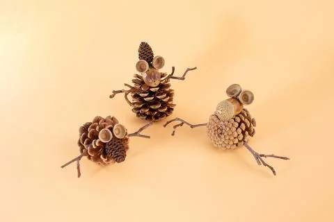 Three crafted figures made from pine cones, acorns, and twigs. Unique natur.. Stock Photos