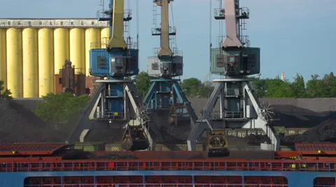 Three Crane Load Coal Into a Barge the Day in the Background, Piles of Coal and Vídeos de archivo 68905191
