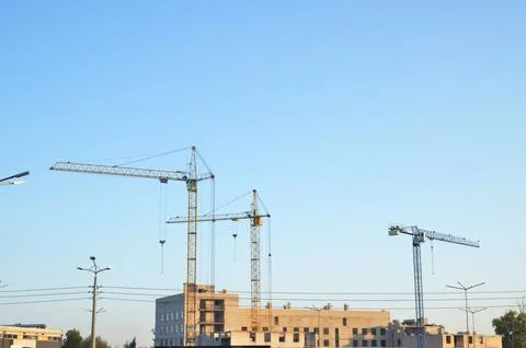 Three cranes above the construction of the building Stock Photos