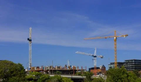 Three cranes on construction site blue sky clouds Stock Photos