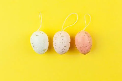 Three creatively painted eggs in pastel colors decorated with gold leaf are a Stock Photos