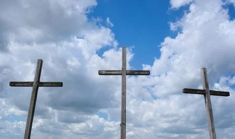 Three crosses on cloudy sky background. Stock Photos