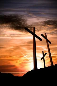 Three crosses on a dramatic sky at sunset Stock Photos