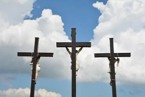 Three crosses in front of white clouds with a blue sky Stock Photos