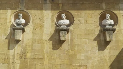 Three crowned monarch sculptures set in circular sandstone wall medallions Stock Footage 342208319
