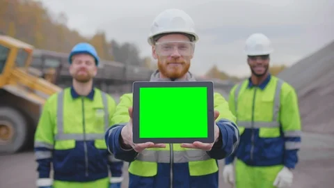 Three crushed stone manufacturing workers with digital tablet looking at camera Stock Footage 124069286