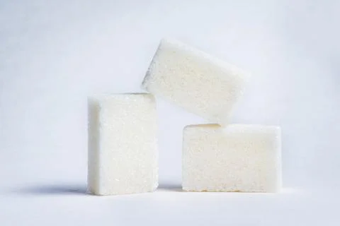 Three cubes of white sugar  Stock Photos
