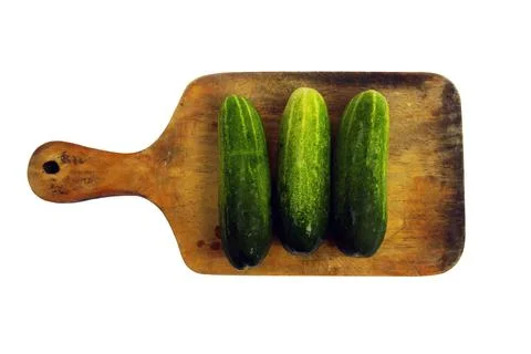 Three cucumbers on a white background on a cutting board for cutting Stock Photos