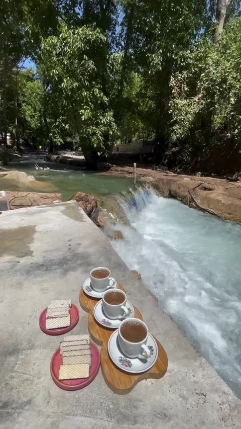 Three Cups of Coffee and Wafers by Rushing River Stream Video stock 340871991
