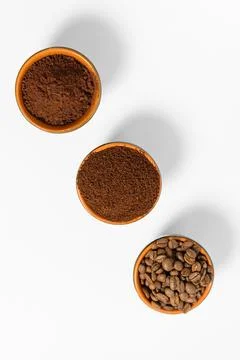 Three cups of coffee beans, ground coffee and cocoa for comparison. Fotos de archivo