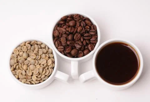 Three cups with different stages of coffee: green and roasted beans and espresso Foto stock