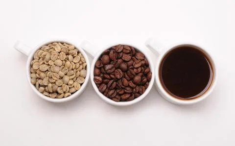 Three cups with different stages of coffee: green and roasted beans and espresso Stock Photos