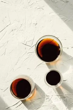 Three cups of fresh brewed coffee on white cement background, selective focus Stock Photos