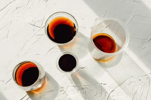 Three cups of fresh brewed coffee and glass cup on white cement background Stock Photos