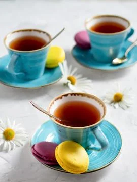 Three cups of tea with macaroons. Stock Photos