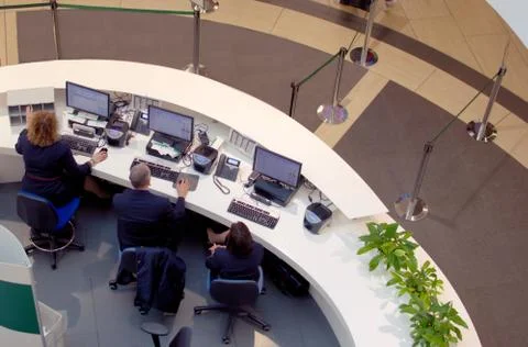 Three customer service agents working at a help desk at the airport. Stock Photos