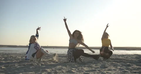 Three dancers synchronously dancing in the sand Видео 146837775