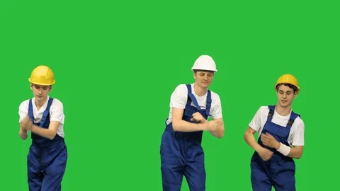 Three dancing construction workers in hard hats on a Green Screen, Chroma Key. Stock Footage 125457113