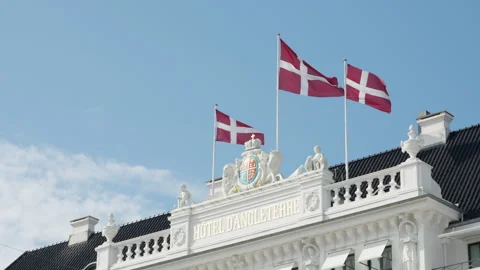 Three Danish national flags wave on Hotel d'Angleterre roof in Copenhagen Video stock 345589687
