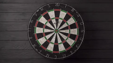 Three darts hit the dartboard on a black wooden background. Lucky - one of the Stock Footage 237873271