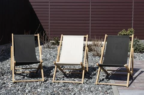Three deck chairs stand in the yard. Recreation area Stock Photos