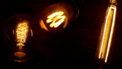 Three decorative filament light bulbs is switch on and gradually off Stock-Footage 127886553
