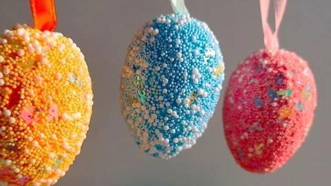 Three decorative multicolored Easter eggs sway Stock Footage 105926164