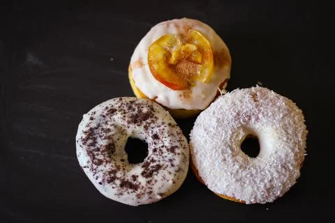 Three delicious Donuts on a black background Stock Photos