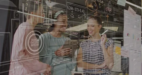 Three designers tapping tablet and generating overlays over UX wireframes for Stock Footage 320128047
