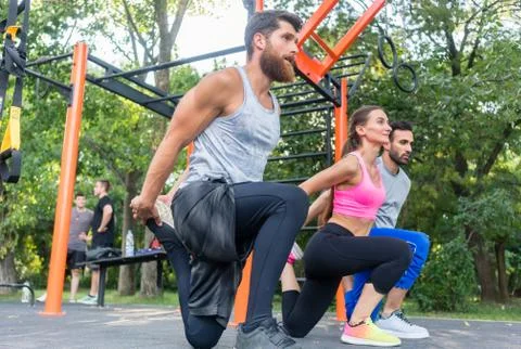 Three determined friends doing stretching exercises for legs as Stock Photos