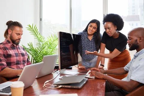 Three developers peer programming together in office, assisting peer review Stock-Fotos