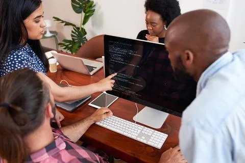 Three developers peer programming together in office, assisting peer review 写真素材