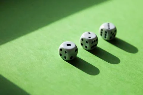 Three dice in a row with the numbers one to three on a green background Stock Photos