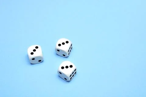 Three dice with the same dropped out numbers lie on a blue background Stock Photos