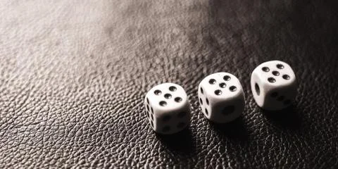 Three dices on the black table. BW photo Fotos Stock