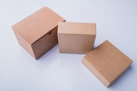 Three different beige cardboard boxes. Stock Photos