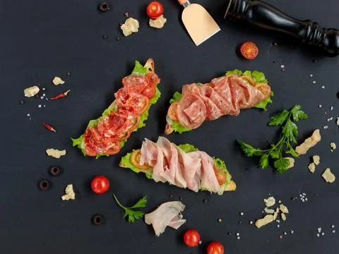 Three different bruschettas on a black background, top view, with cooking Stock Photos