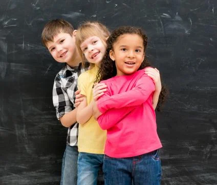 Three different children stand one by one peeking out from behind each other Photos