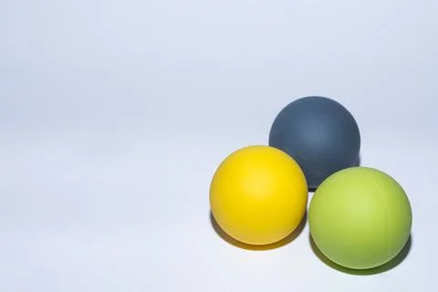 Three different colored balls for massage on gray Stock Photos