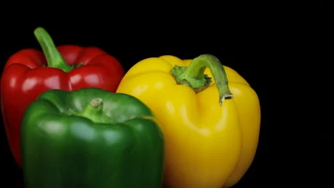 Three different colored bell peppers isolated against the black background. Red Видео 146469345
