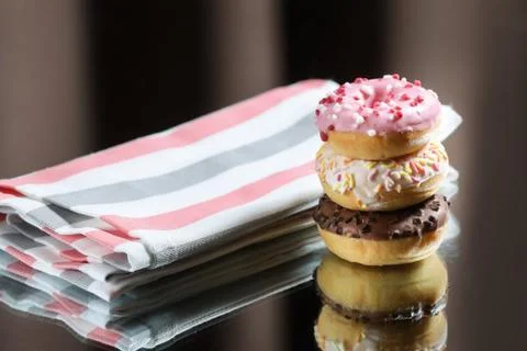 Three different donuts , kitchen towel on a light and dark background Stock Photos