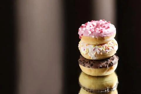Three different donuts with reflection on a light and dark background Stock Photos