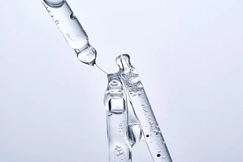 Three different face serum pipettes on a neutral background. Stock Photos